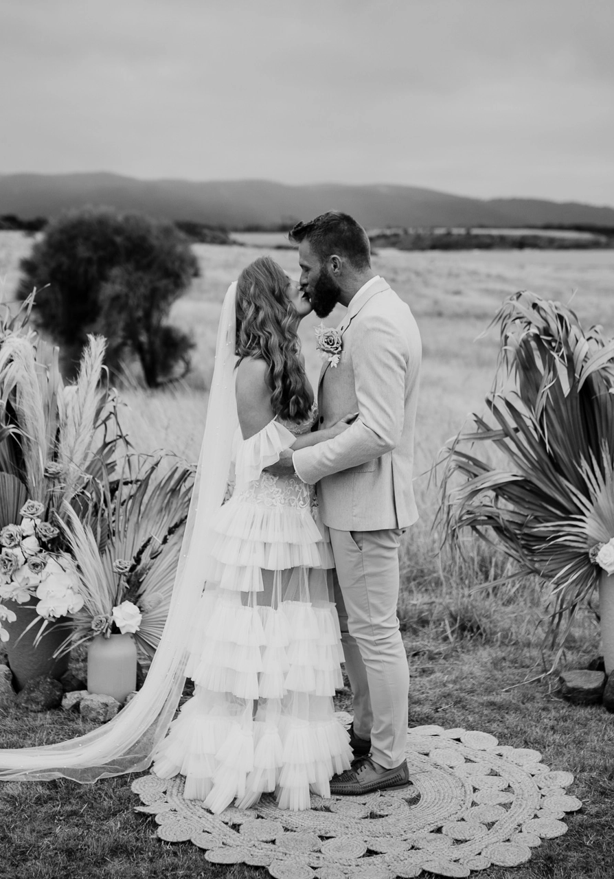 Black and white photo of bride and groom kissing at an elopement ceremony, performed by Tasmanian wedding celebrant Rachael Calvert
